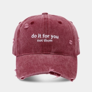 Macro detail of embroidery on distressed burgundy washed cotton baseball cap