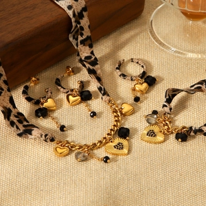 Golden jewelry set with leopard print hearts, necklace and earrings on beige texture