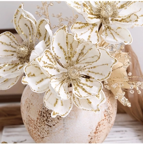 Detailed close-up of premium white velvet Christmas flowers with golden sequins in a vase