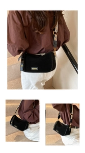Detail view of black suede crossbody bag with geometric pattern wide shoulder strap