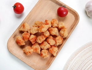 Detailed macro view of realistic faux fried chicken wings on a rustic wooden tray