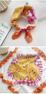 Detail of cotton linen scarf featuring yellow sunflower smiles and positive vibes text