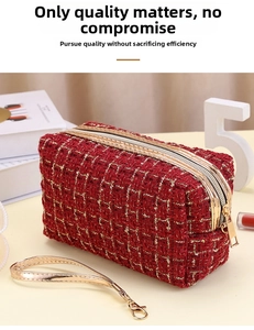 Detail der roten Tweed-Kosmetiktasche mit Goldreißverschluss und Ledergriff auf Dekohintergrund