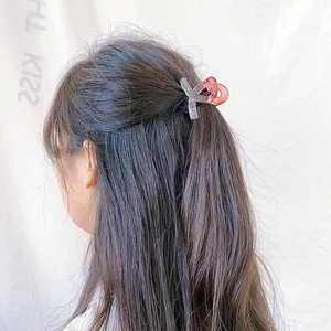 Detail of gradient acetate hair claw clip holding hair in a stylish half-up hairstyle