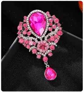 Detailed view of luxury teardrop pink crystal brooch with rhinestones on black velvet