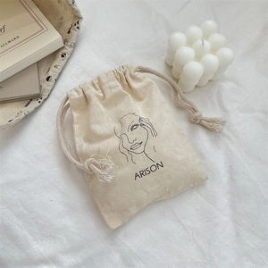 Detailed view of canvas fabric texture and minimalist line art on drawstring bag