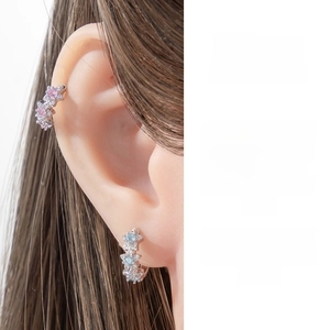 Detail of minimalist five-petal star earrings with pink and blue micro-set zircons