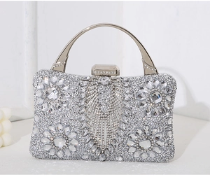 Detailed macro view of handcrafted floral crystal rhinestones on a silver evening bag