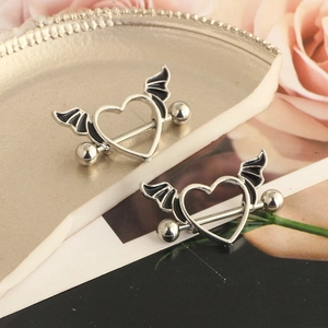 Silver winged heart nipple rings set on a decorative plate with pink roses