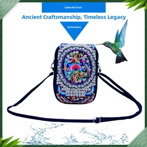 Detail showing colorful floral embroidery and butterfly patterns on a navy blue fabric bag