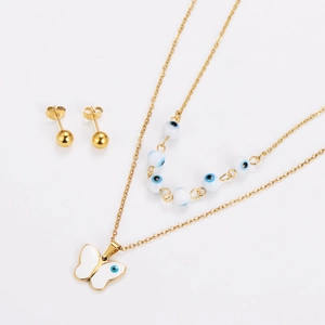 Detail of evil eye necklace and gold stud earrings set featuring a white butterfly pendant
