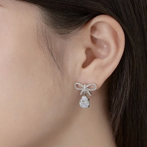 Close-up of S925 silver bowknot teardrop earrings with pavé zircon stones on model