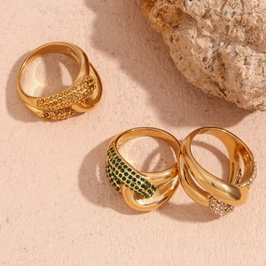 Detail of 18K gold plated knotted rings with inset yellow green and white zircons