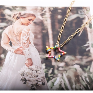 Detailed close-up of a gold hip hop necklace featuring a colorful zircon star pendant