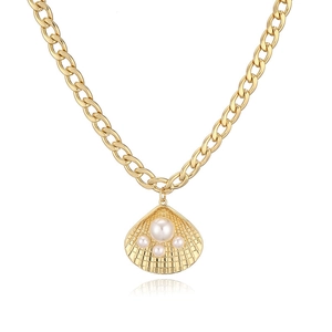 Detailed view of a gold shell pendant with white pearls on a chunky Cuban link chain