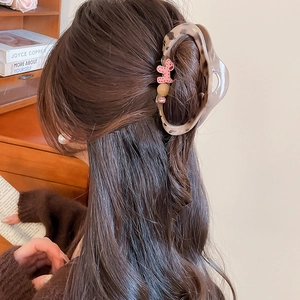 Detail of leopard print hair claw with pink puppy motif and crystal on model's hair