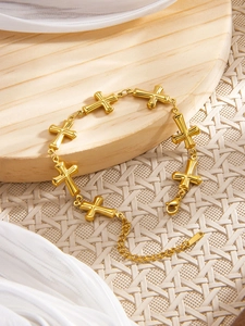 Close-up of 18k gold plated bracelet featuring 3D cross charms and lobster clasp detail