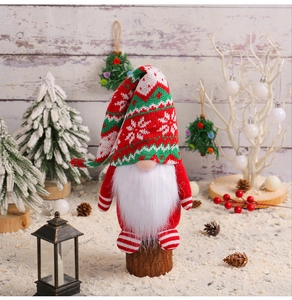 Festive Christmas gnome with knitted snowflake hat standing on wood in snowy scene