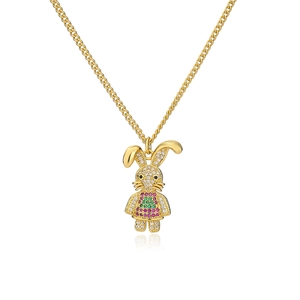 Collana con ciondolo a forma di coniglio dorato con zirconi colorati su fondo bianco