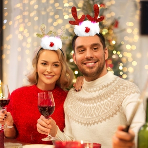 Close-up of red and gold sequined reindeer antler headband with white faux fur decor