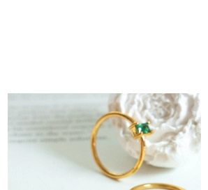 Detailansicht eines 18k vergoldeten Rings mit quadratischem grünem Edelstein im Zentrum