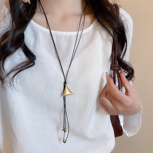 Detail of a minimalist leather cord necklace with double-layered triangle cone pendant