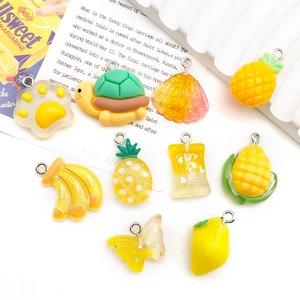 Close-up of yellow resin pendants in pineapple and shell shapes for DIY jewelry making