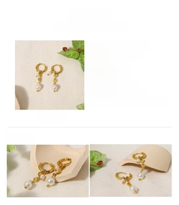 Detail of long pearl drop earrings with gold floral charms and 18K gold-plated hoops