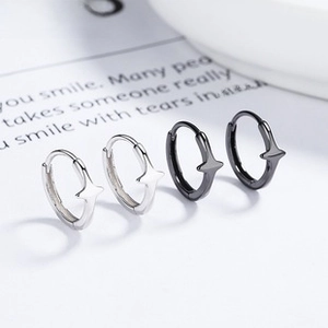 Macro detail of 925 silver star earrings in polished silver and matte black finish