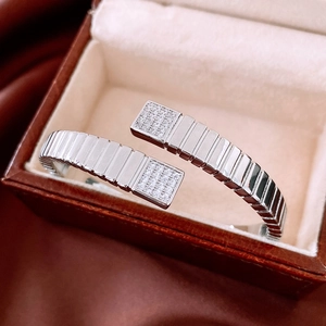 Detailed close-up of a silver caterpillar-style open bangle with micro-pave zircons