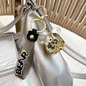 Porte-clés panda avec sable mouvant liquide et étoiles dorées sur sac à dos argenté