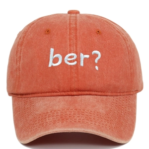 Macro detail of retro washed cotton baseball cap with blue ber? embroidery on deep orange