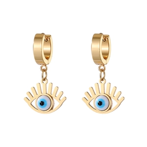 Detailed macro view of golden Evil Eye drop earrings with blue enamel and ring closure