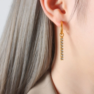 Orecchini a barra placcati oro 18K con zirconi scintillanti indossati da una modella