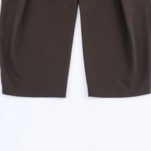 Vue détaillée de l'ourlet et des coutures du pantalon de costume marron foncé