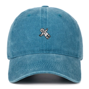 Close-up of astronaut embroidery and stitch details on washed denim baseball cap