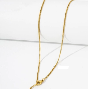 Close-up of golden stainless steel chain featuring a lobster clasp on white background