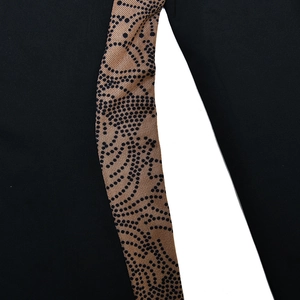 Detailed macro shot of black and brown leopard print splicing on black fabric texture