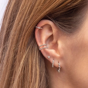 Close-up of S925 sterling silver beaded earring set with twist design on ear model