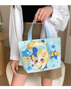 Light blue canvas tote bag with a cute cat print and snap closure shown held by a model