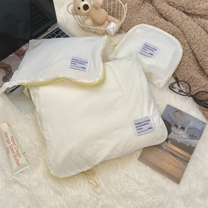 Three-piece cream white waterproof travel organizers with yellow zippers and woven labels