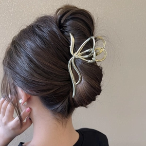 Elegant large gold metal butterfly hair claw clip for thick hair shown on model's hairstyle