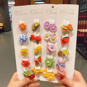 Close-up of cute girls hair ties featuring colorful resin flowers and fruit charms on cards