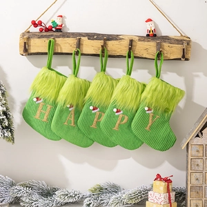 Set of five green knitted Christmas stockings with gold glitter letters spelling HAPPY