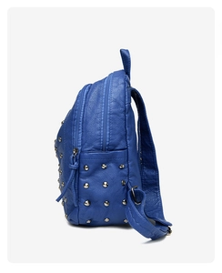 Detail of blue textured leather backpack featuring silver side rivets and zipper pocket