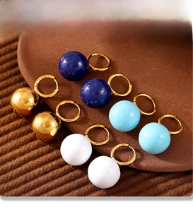 Dettaglio di orecchini a sfera placcati PVD in oro, bianco e vari colori blu pastello