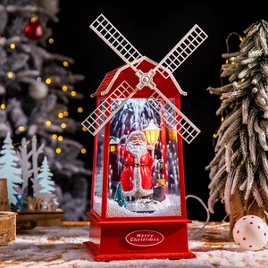 Lanterne moulin de Noël rouge avec Père Noël et effet neige sur fond de sapin festif