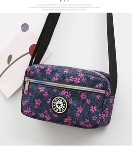 Detail of blue floral oxford fabric bag with SPORT logo and dual zipper pockets