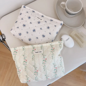 Floral quilted cotton makeup bags with simple wish label on a white aesthetic desk