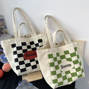 Detail of checkerboard canvas tote bags with Boom text in a minimalist lifestyle setting